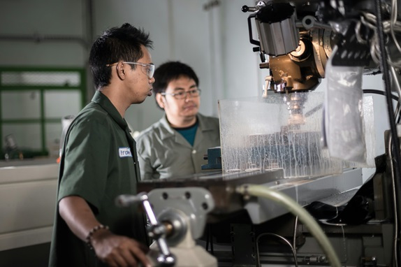 Machinists operating a milling machine - traditional machining